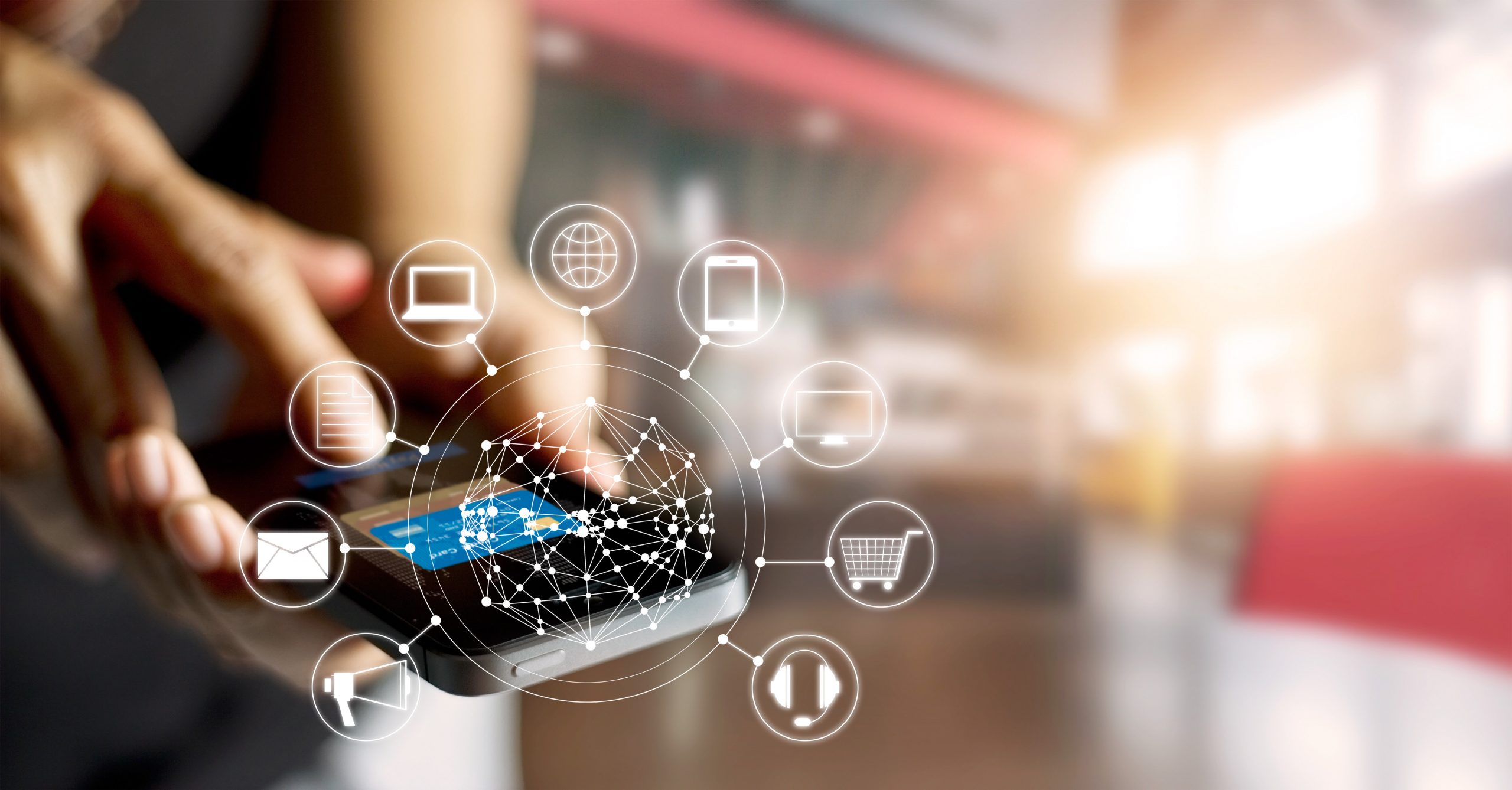 Hand holding a Mobile Payment Device with computer animated shopping Icons surrounding it